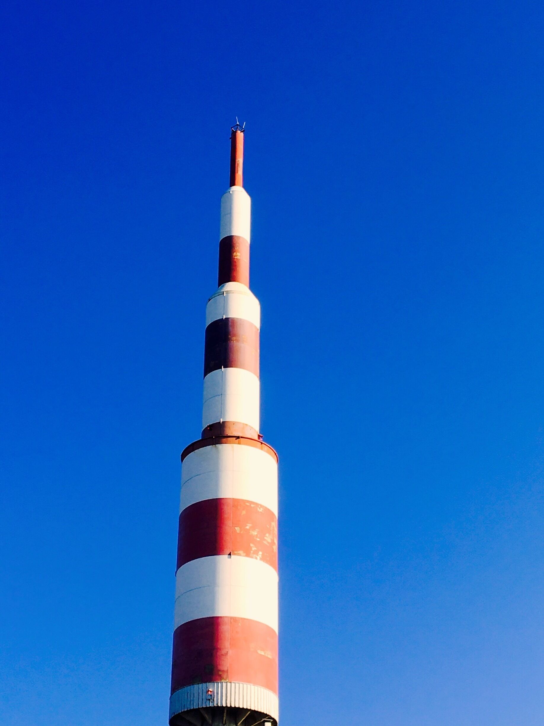 A tall, striped tower against a clear blue sky.