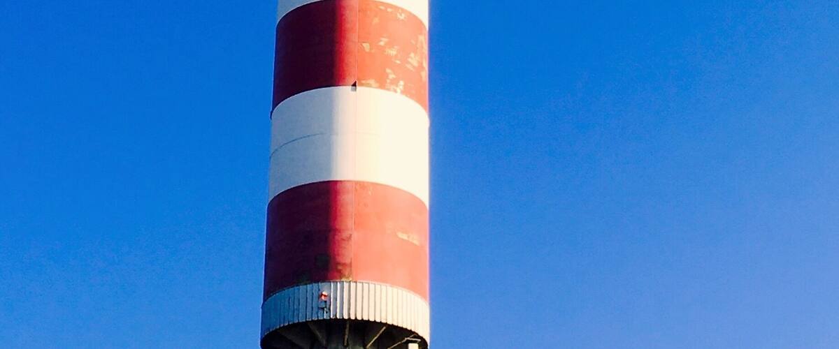 A tall, striped tower against a clear blue sky.