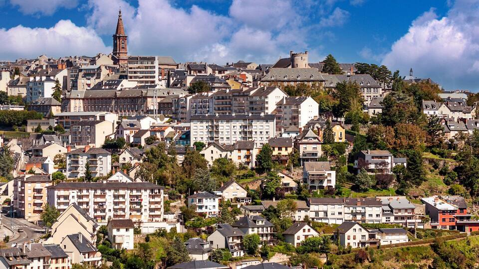 A densely built hillside town with historic buildings and a prominent church tower.