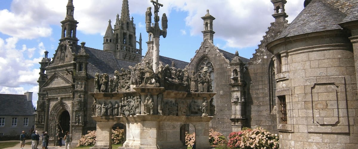 Una iglesia histórica con elaboradas esculturas de piedra y una gran estatua central.