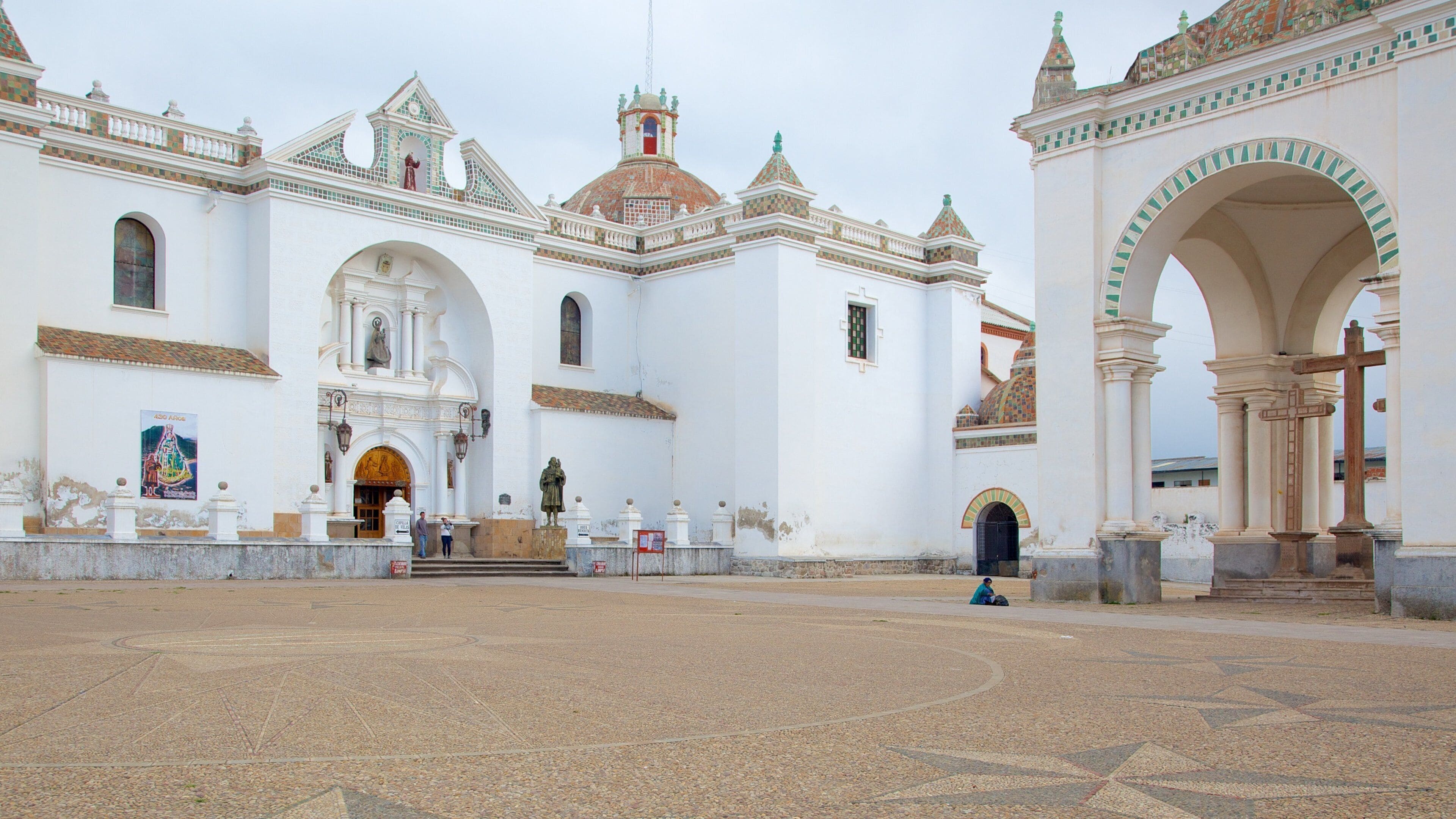 A historic white church with a tiled roof, a central dome, and a bell tower.