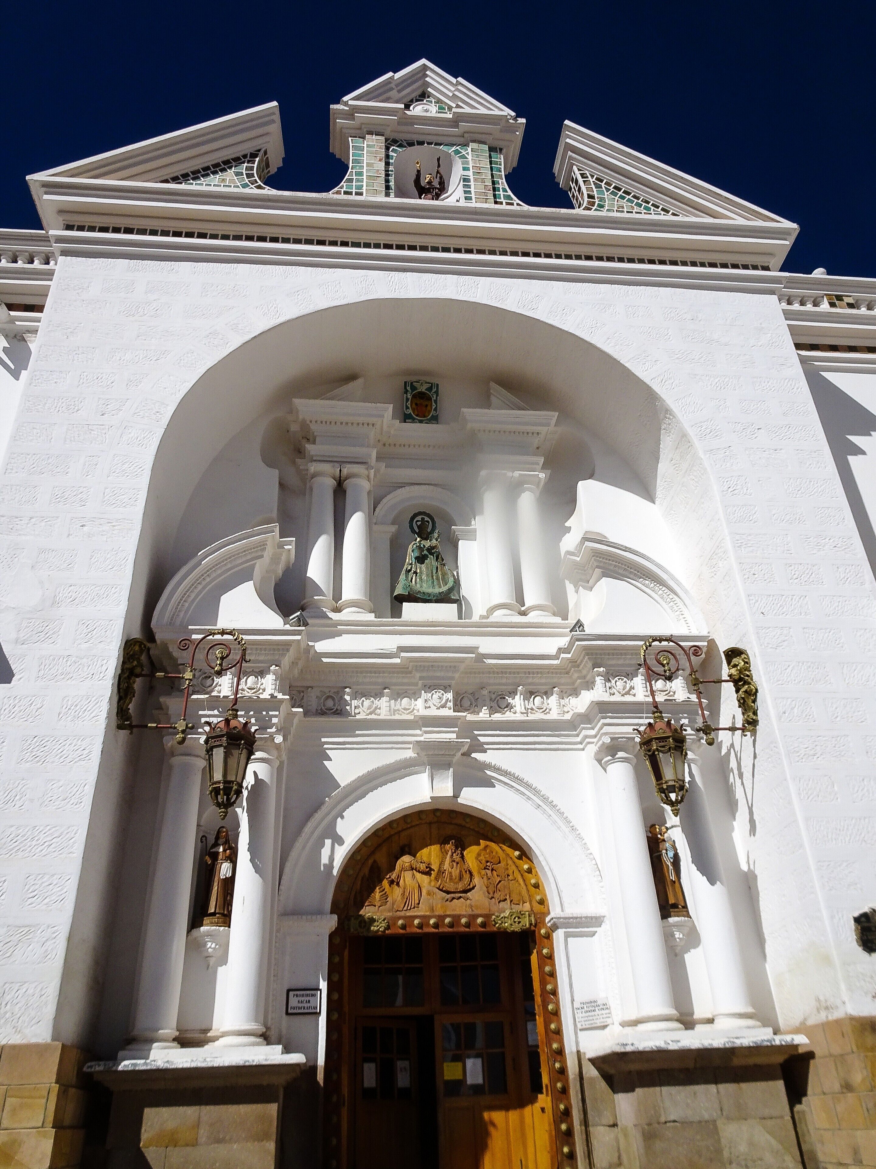 A white church with a large arched entrance, columns, and a bell tower.