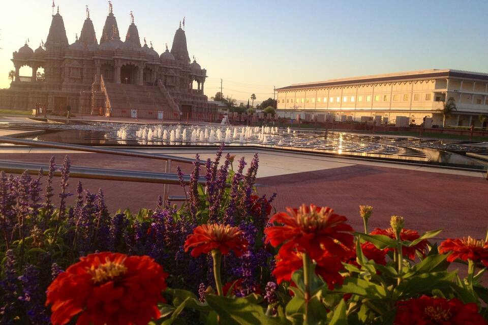 Um templo com várias cúpulas e um edifício grande ao fundo.