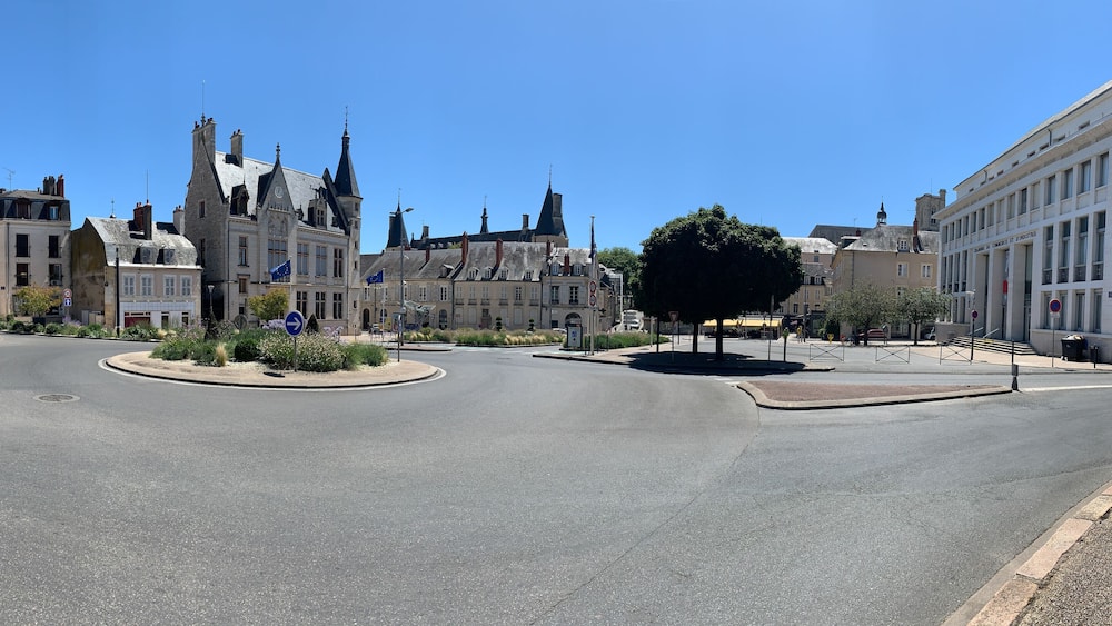A roundabout with historic buildings, including a prominent Gothic-style structure with multiple spires.