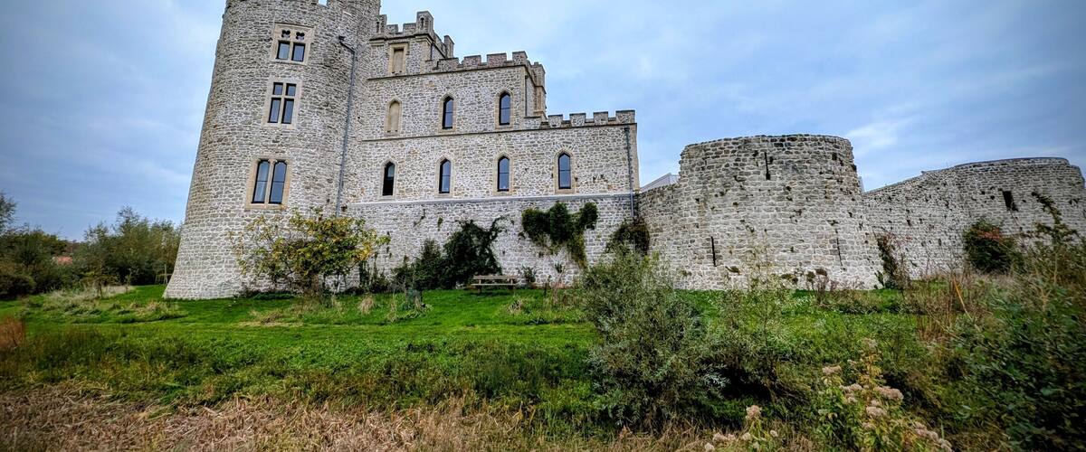 A historic stone castle with multiple towers and a flag.