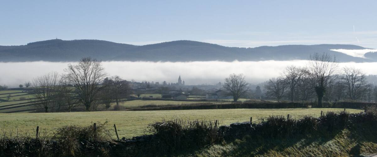 Rolling hills, a village, and a mist-covered valley.