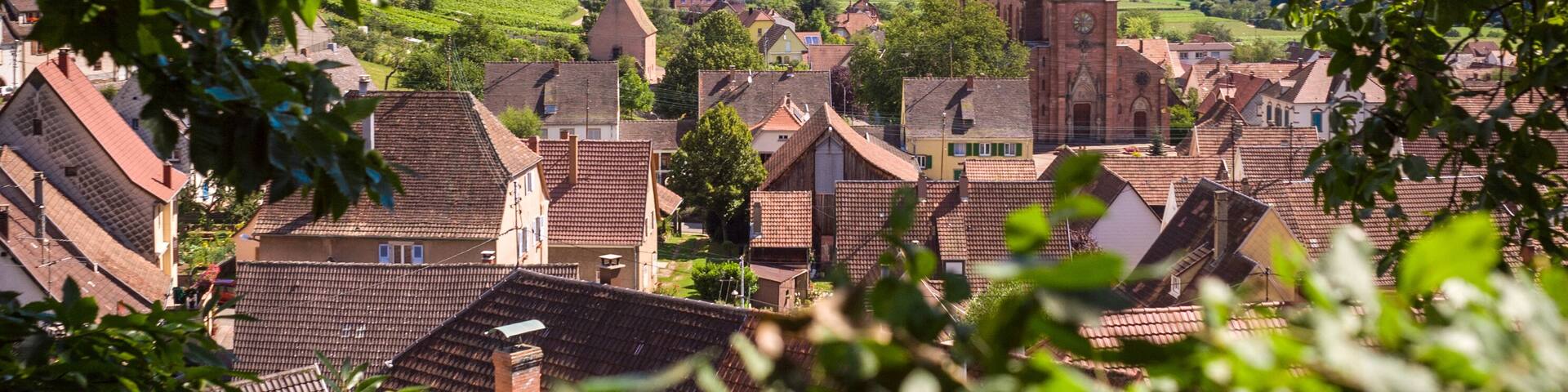 Panoramic view of the typical alsatian village Wihr-au-Val with rooftops, church and hills in the background