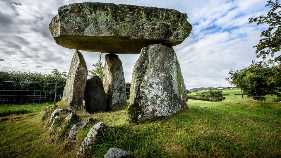 A standing stone circle with a large central stone balanced on top of four supporting stones.