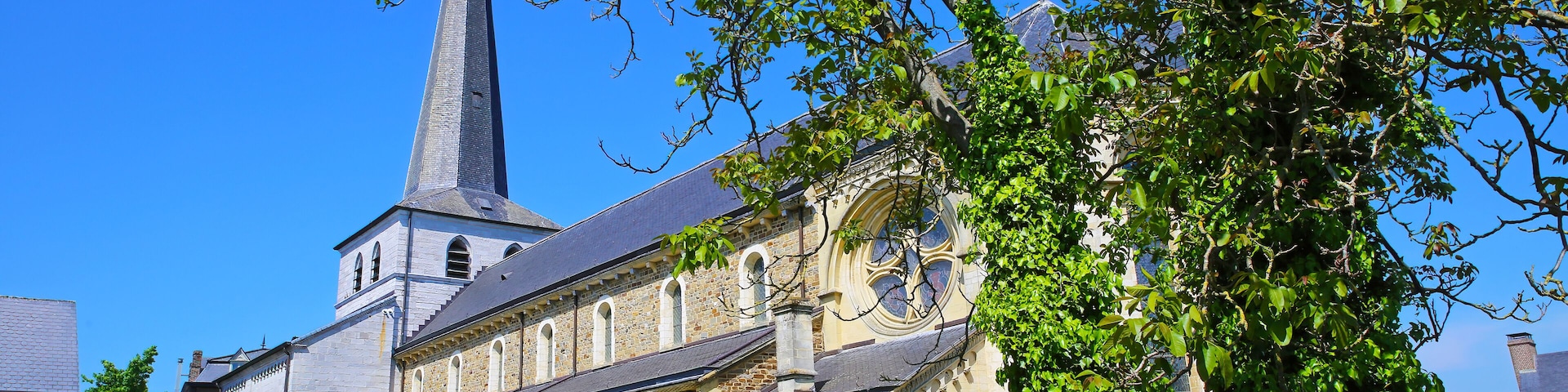 Una iglesia histórica con un campanario alto y ventanas arqueadas.