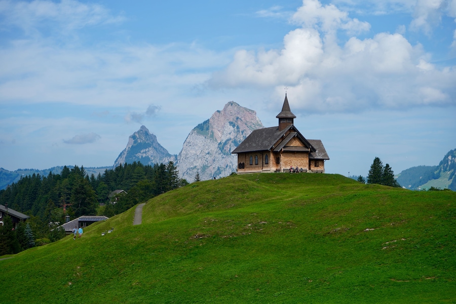 A church on a hill with a mountain in the background.