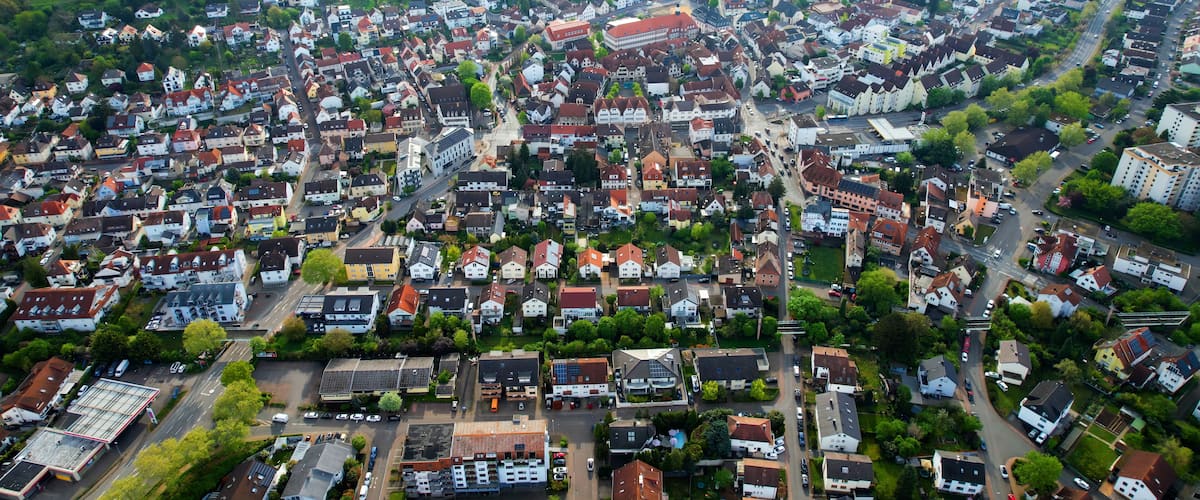 An aerial view of a densely populated town with a mix of residential houses and commercial buildings.