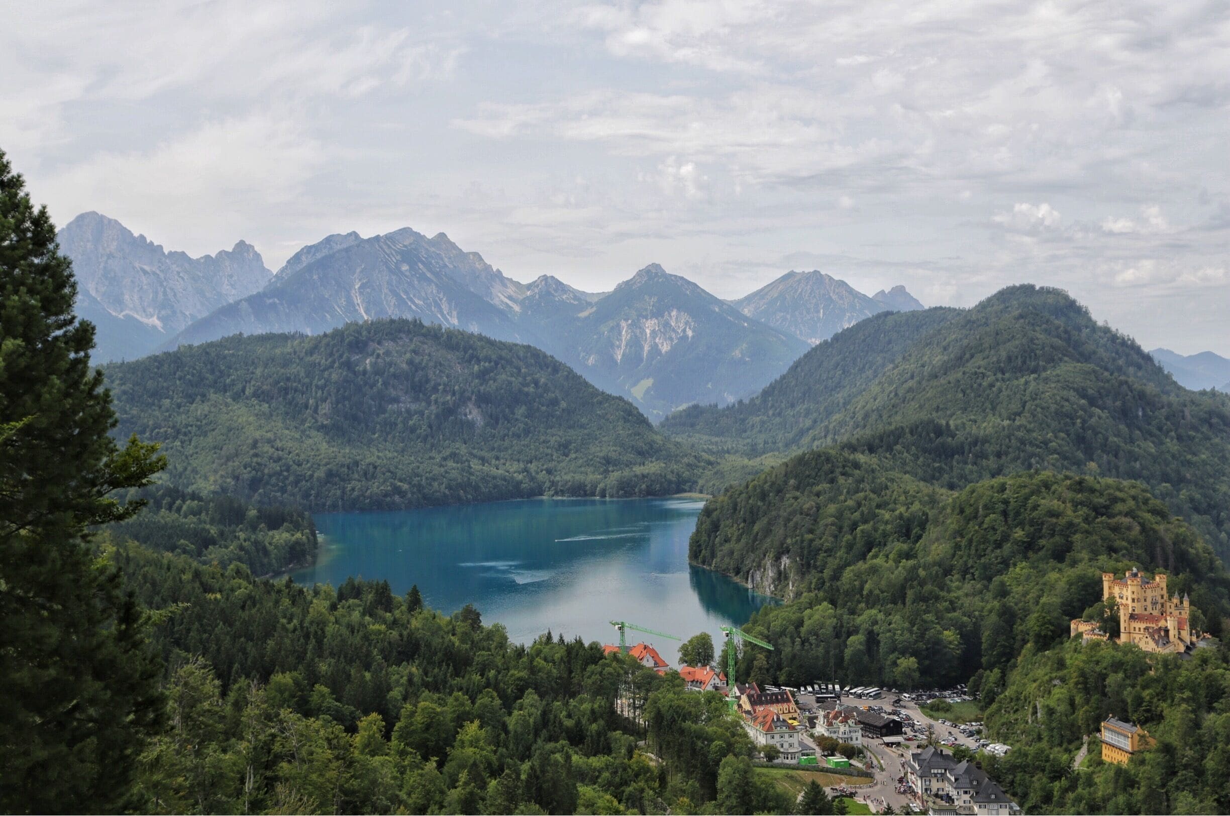 An overview of King Ludwig's childhood home, Hohenschwangau Castle in the right side of the photo with the Alpsee Lake in the center. Be sure to book lots of time here and wander onto the hiking trails all around the area.  Such a magical area to visit in Bavaria.
#takeahike #europe