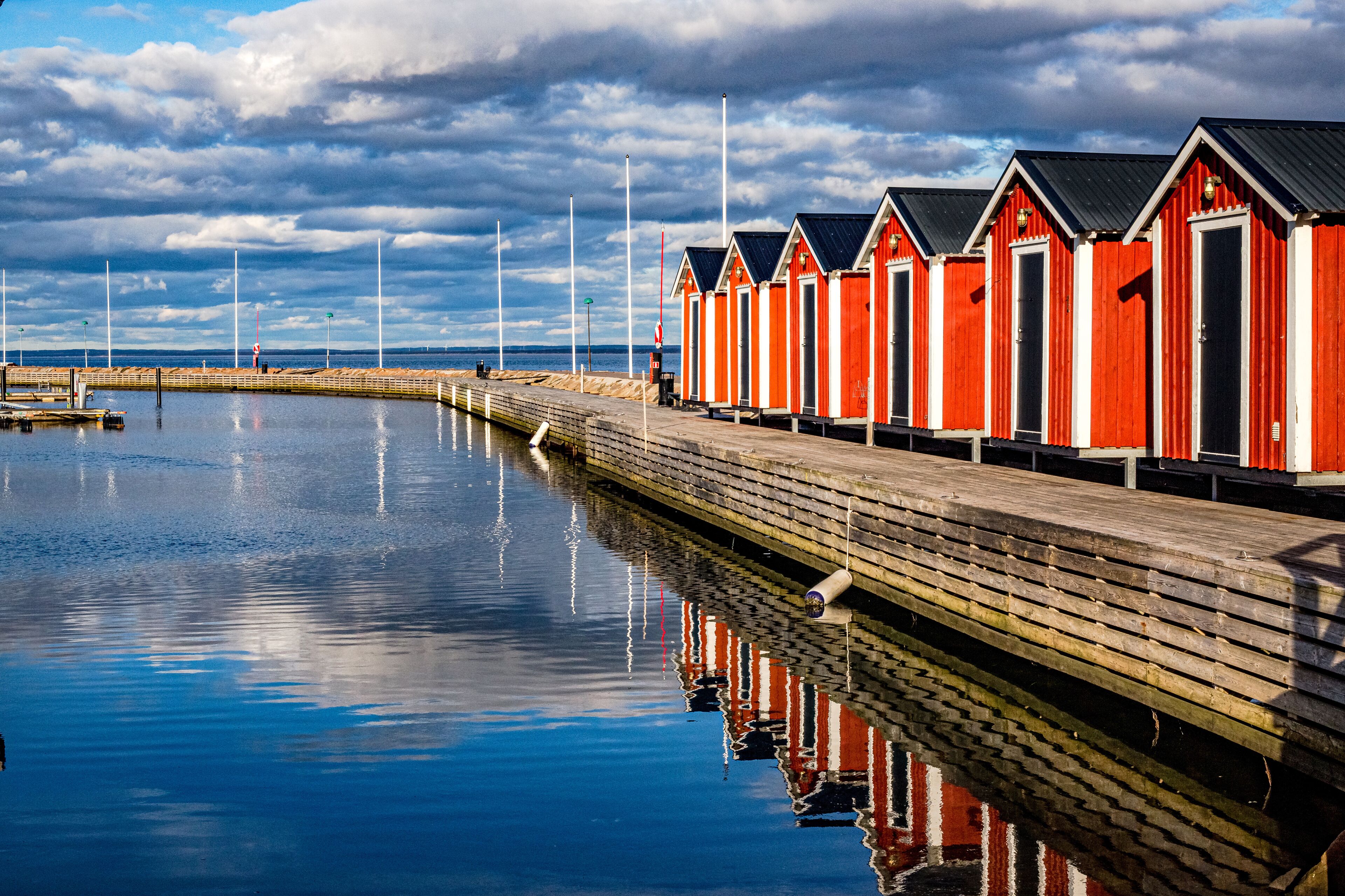 Red boat houses in line in Bastad harbor, Sweden