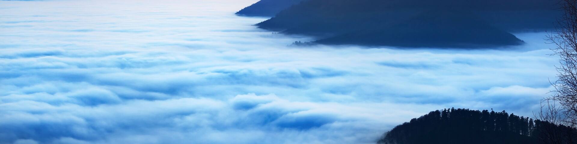A mountainous landscape with a sea of clouds below.