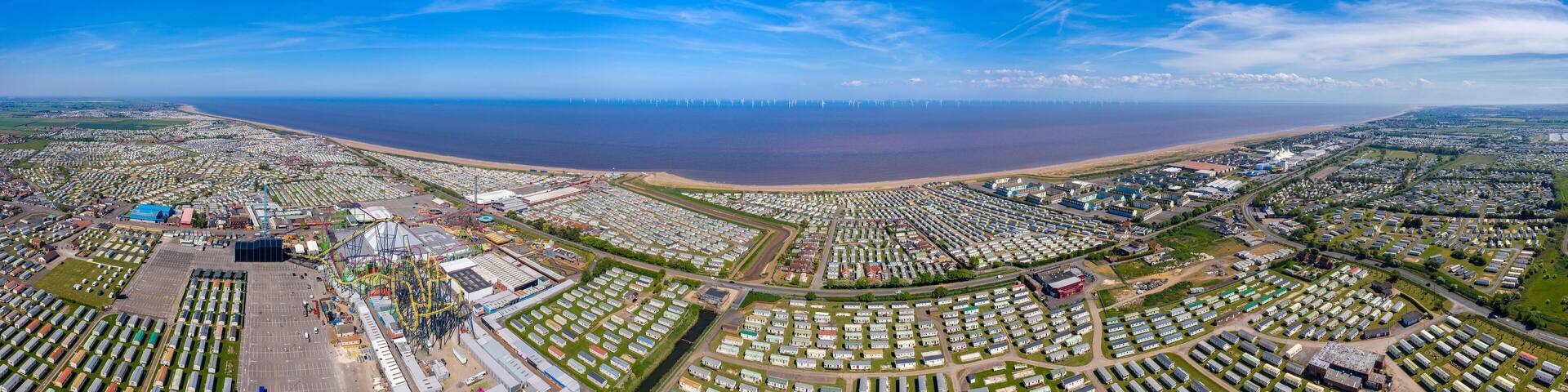 Aerial wide photo of the town centre of Skegness showing the the sandy beach near fairground rides in the East Lindsey district of Lincolnshire, England