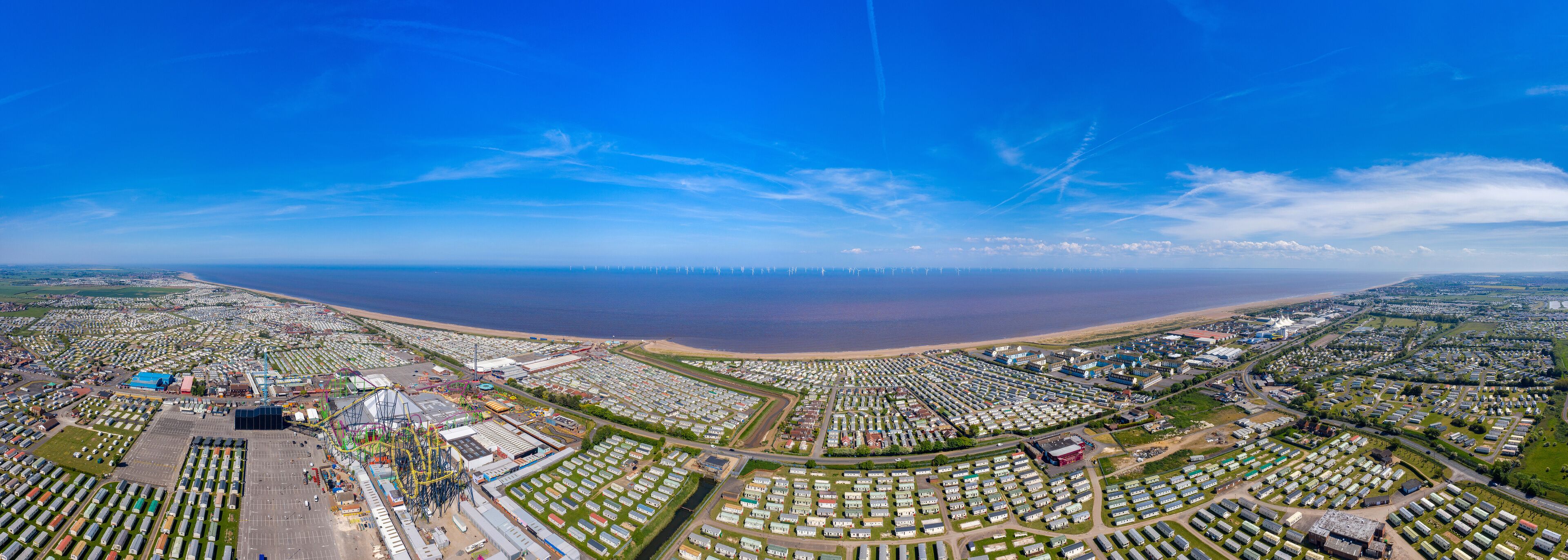 An aerial view of a coastal area with a large marina, numerous mobile homes, and a beach.