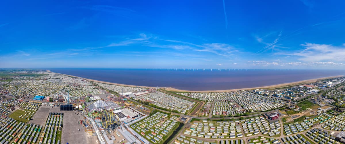 An aerial view of a coastal area with a large marina, numerous mobile homes, and a beach.