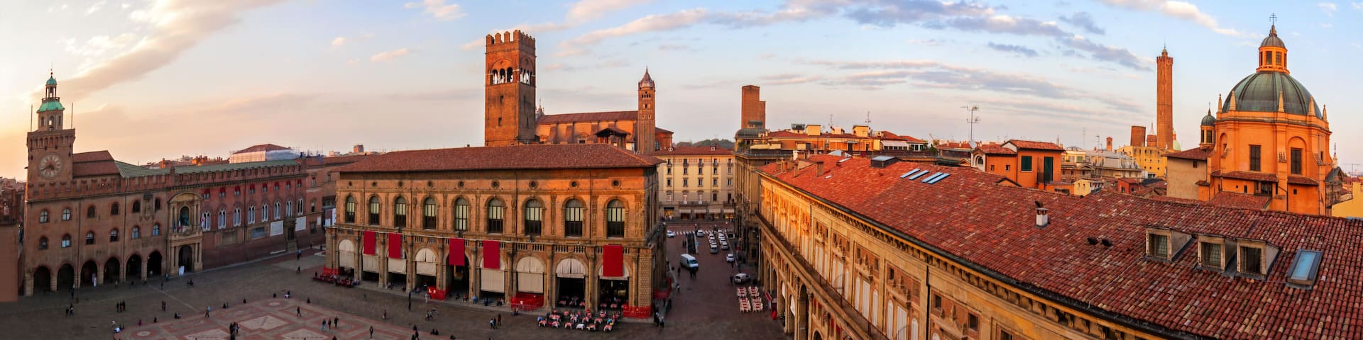 A historic square with a prominent building featuring a clock tower, surrounded by other notable architecture.
