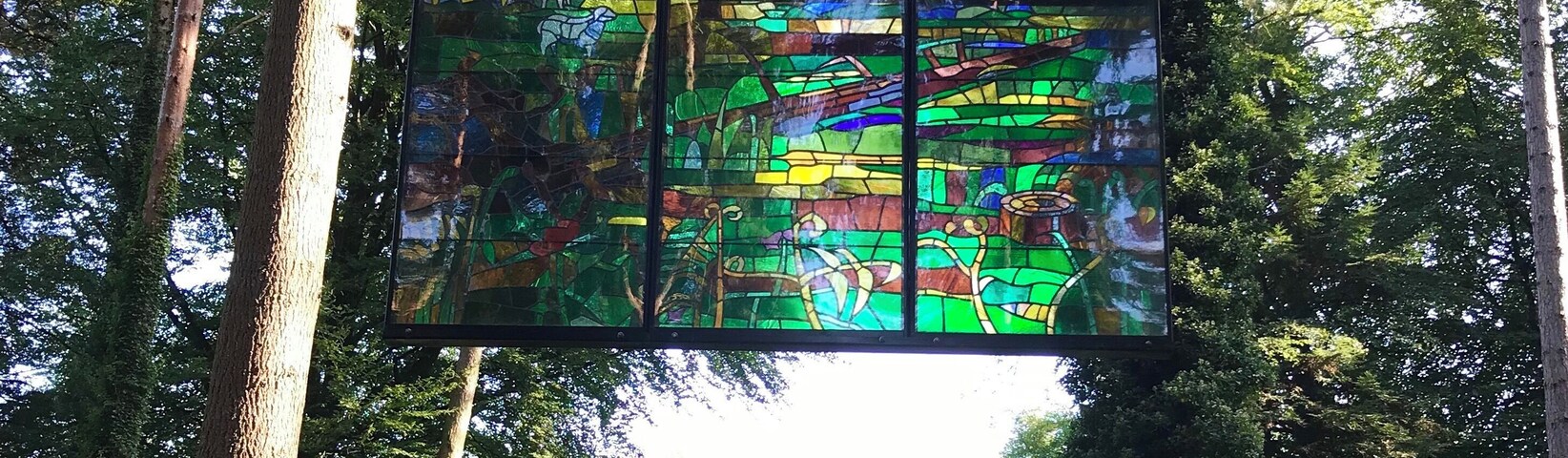 A beautiful stain glass window in the middle of the forest.