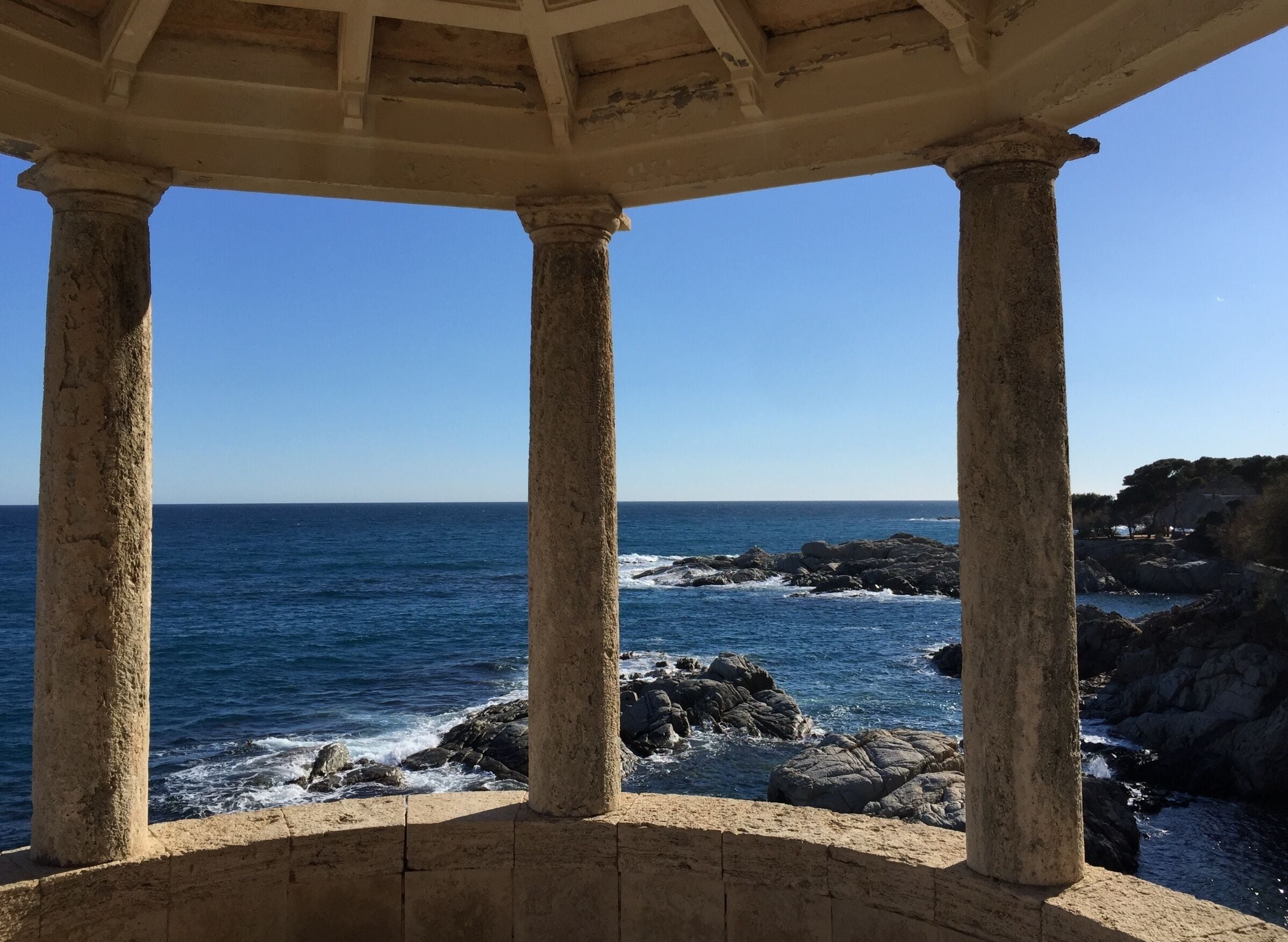 Un paysage côtier avec une structure en pierre dominant l’océan.