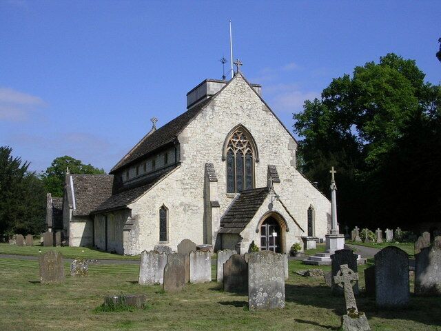 A stone church with a pointed roof and a large arched window.
