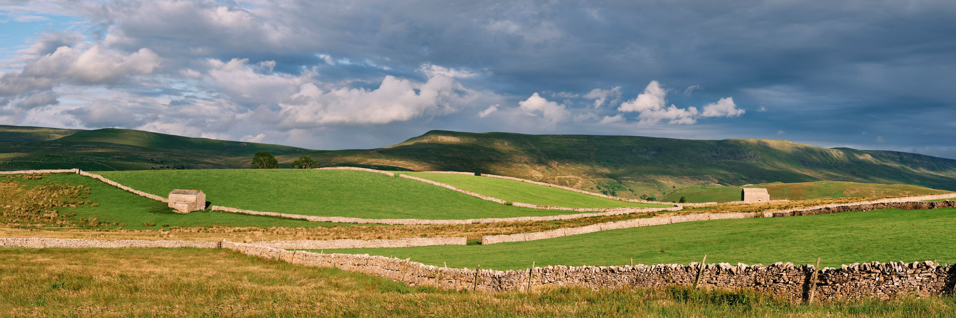 Barns at sunset with Wild Boar Fell beyond. Cumbria, UK.