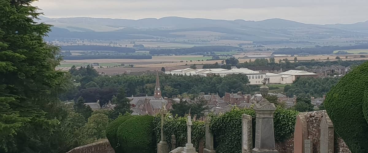 A cemetery with stone monuments and a church in the background.