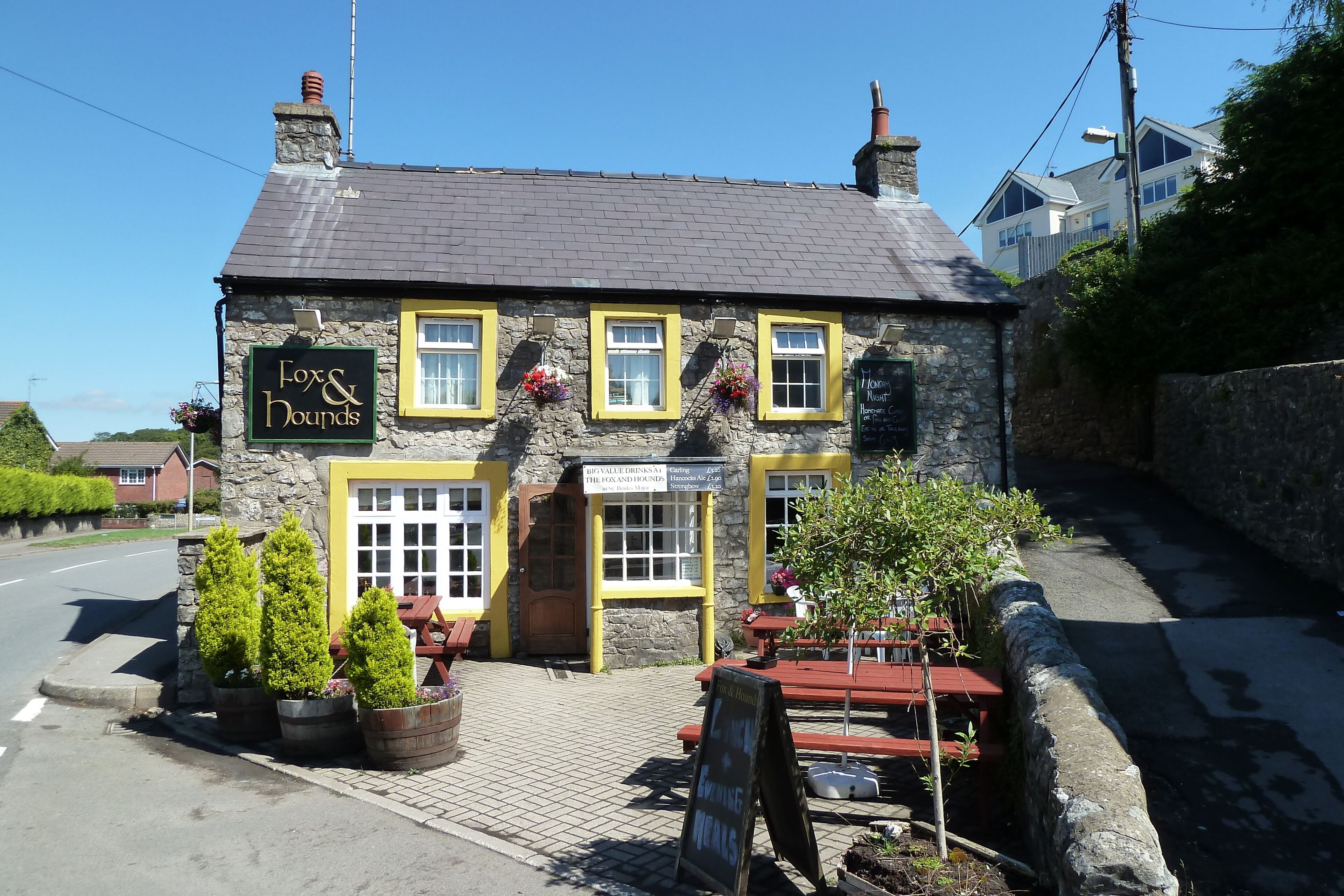 A stone building with a sign reading "Fox & Hounds."