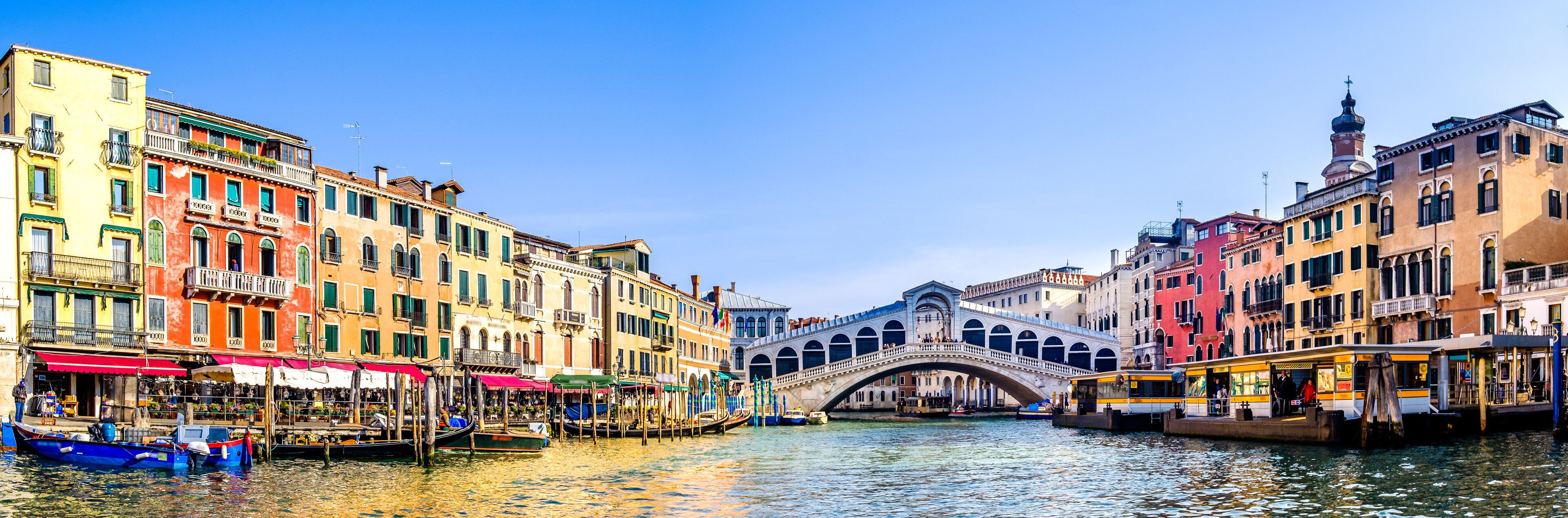 A canal with colorful buildings and a stone bridge.