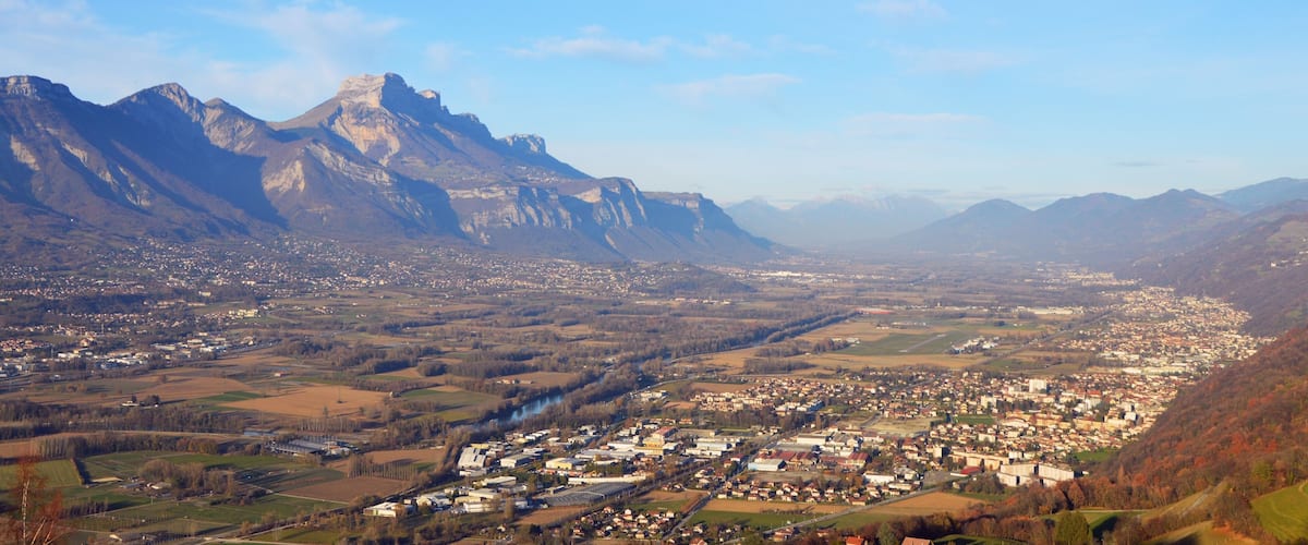 A town nestled in a valley with mountains in the background.