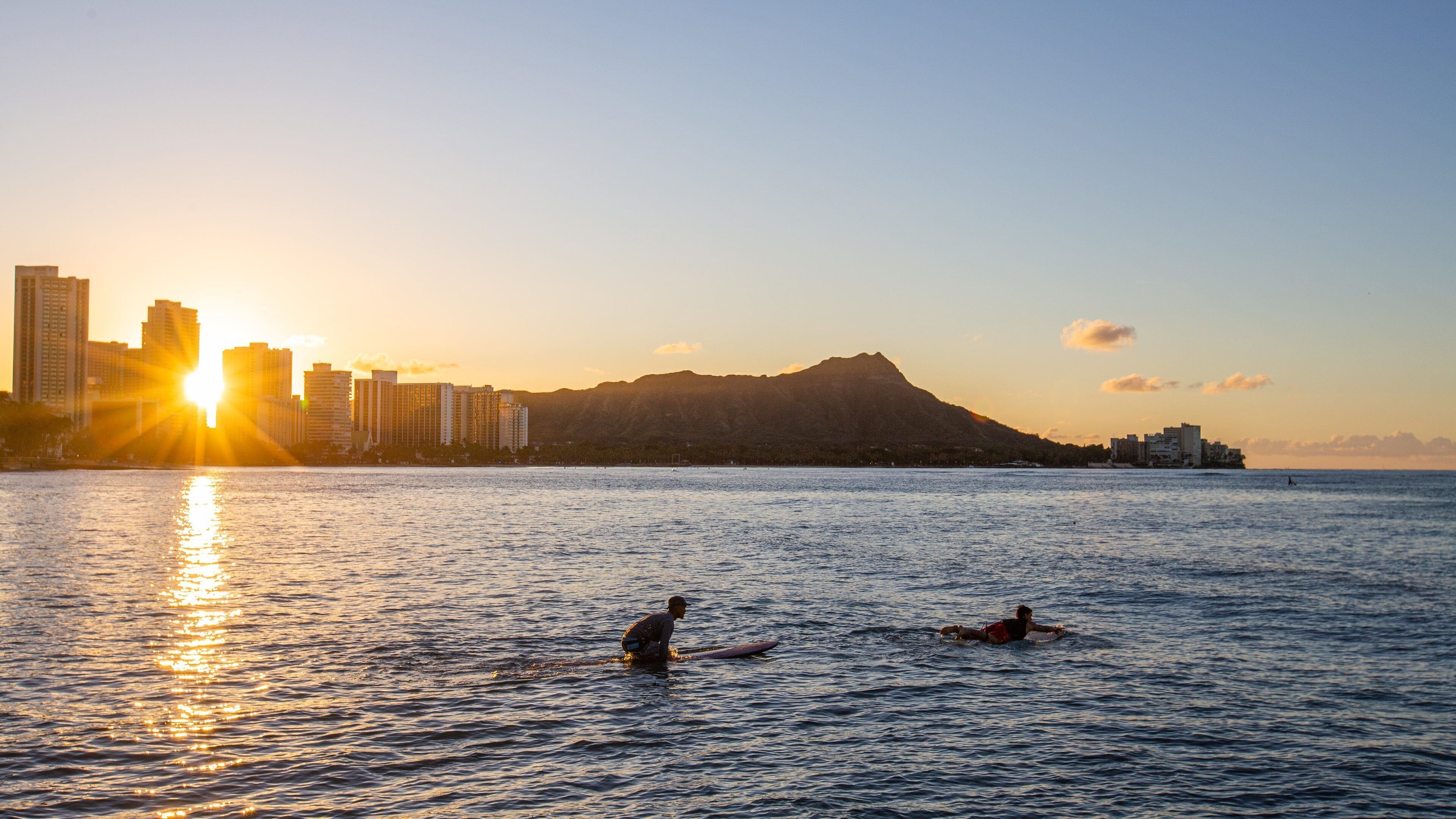 Waikiki showing surfing, a sunset and general coastal views