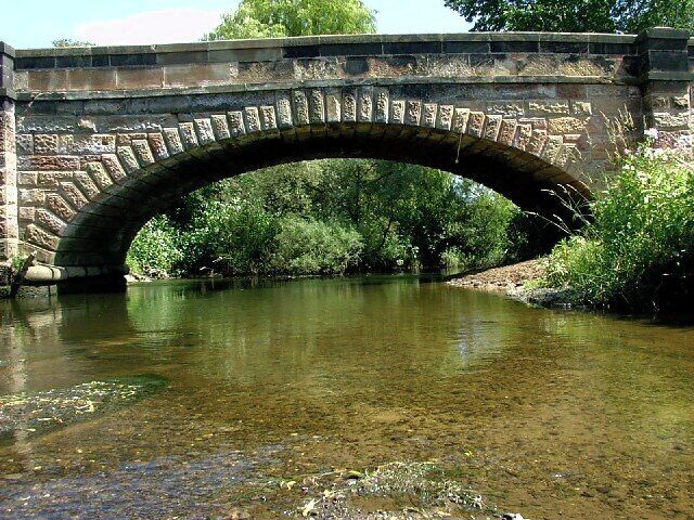 A stone bridge arching over a river.