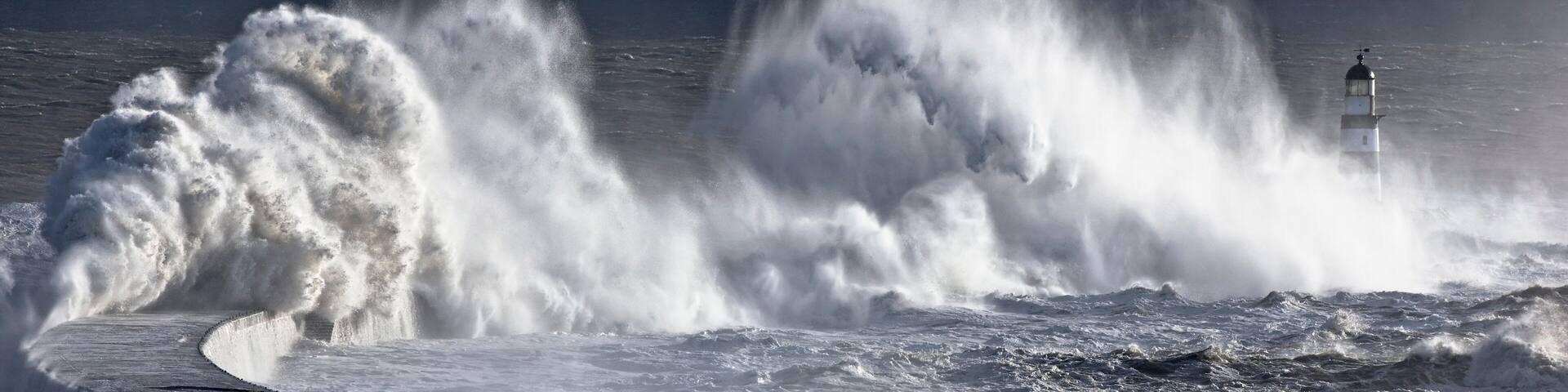 Waves crashing on lighthouse, Seaham, Teesside, England, UK