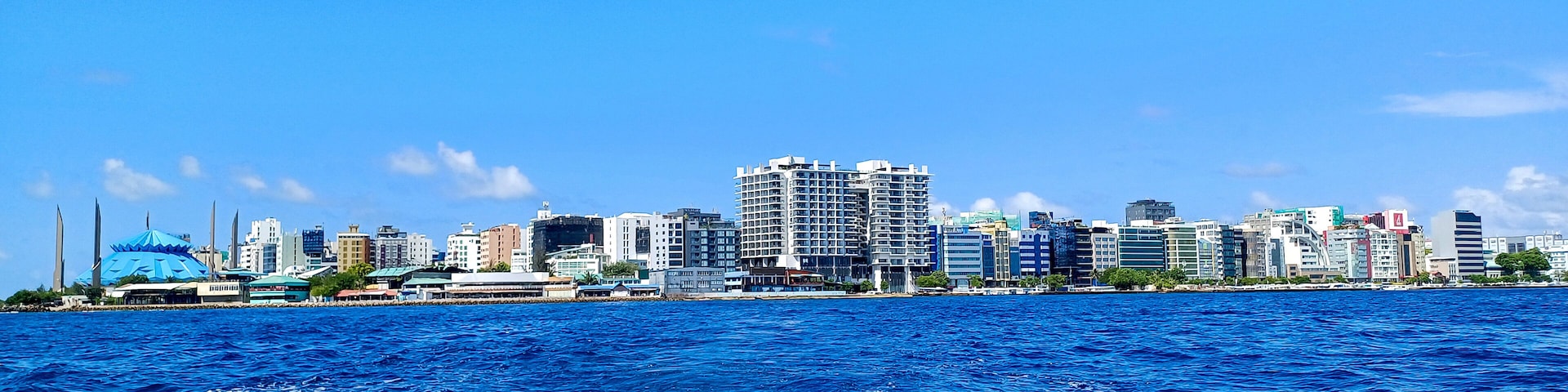 Linha do horizonte costeira com edifícios modernos e céu azul límpido.