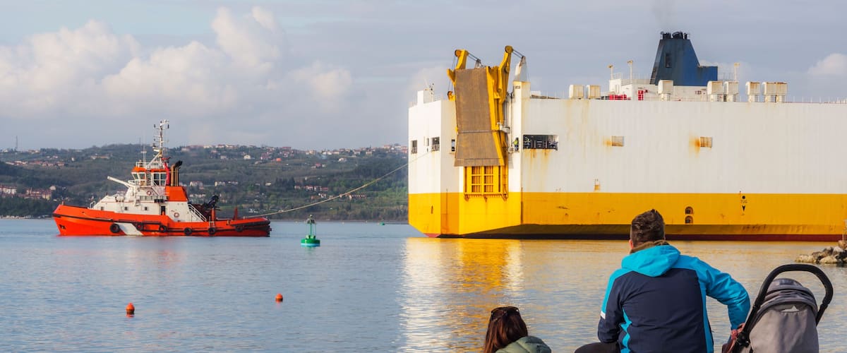 Container ship with tug boat at the port of Koper in Slovenia