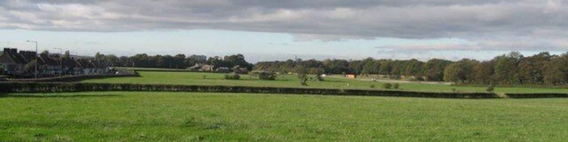 Fields off Knowsley Lane, Huyton This is the boundary of the built up area of Huyton and where the vast 20th century housing estates give way to green fields. On the left can be seen the houses of Lyme Grove on Knowsley Lane, in the centre Knowsley Lane Farm and to the right, beyond the M57 motorway, the woods surrounding Knowsley Hall.