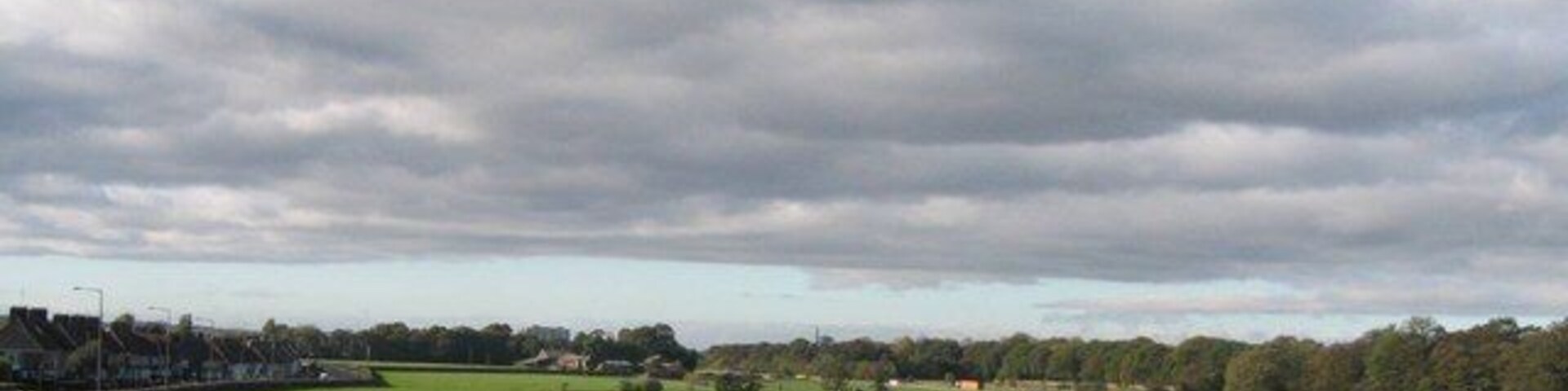 Fields off Knowsley Lane, Huyton This is the boundary of the built up area of Huyton and where the vast 20th century housing estates give way to green fields. On the left can be seen the houses of Lyme Grove on Knowsley Lane, in the centre Knowsley Lane Farm and to the right, beyond the M57 motorway, the woods surrounding Knowsley Hall.