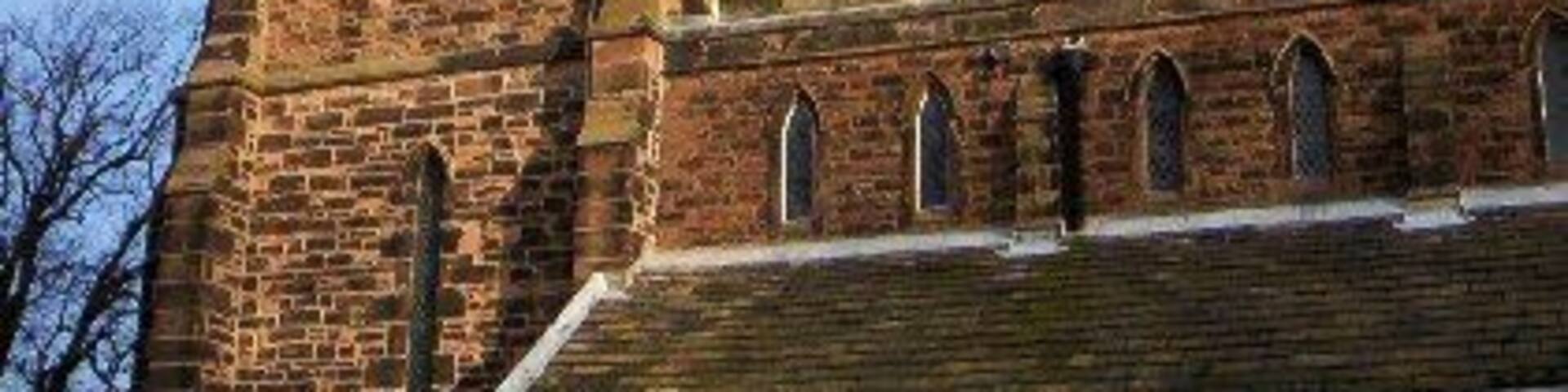 A historic church with a tall spire and arched windows.