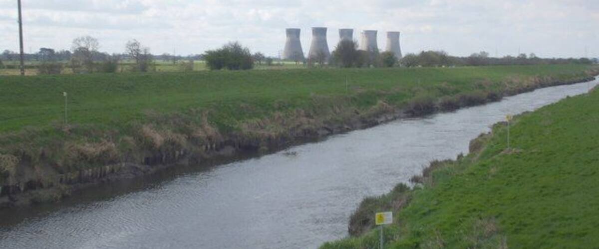 A river with industrial cooling towers in the background.
