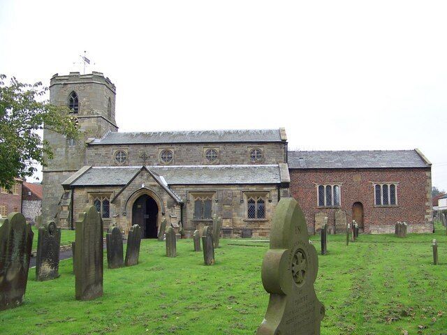 A church with a stone facade, a tower, and a graveyard with headstones.