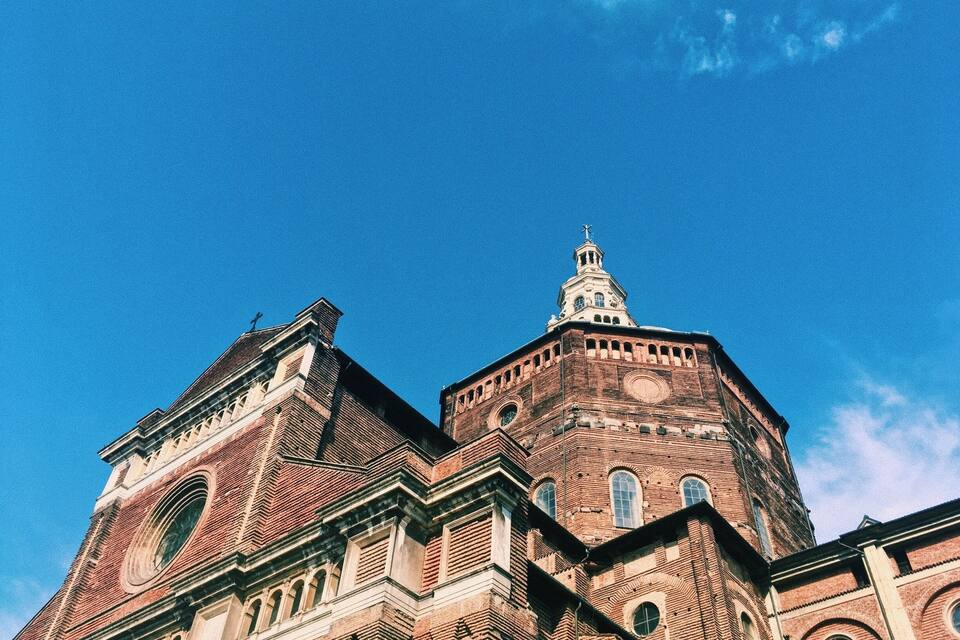 A large brick building with a prominent tower and arched windows.