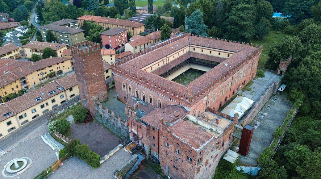 aerial view about Carimate Castle surrounded by green wild forest in sunrise lights