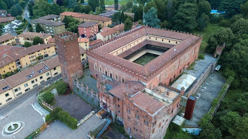aerial view about Carimate Castle surrounded by green wild forest in sunrise lights