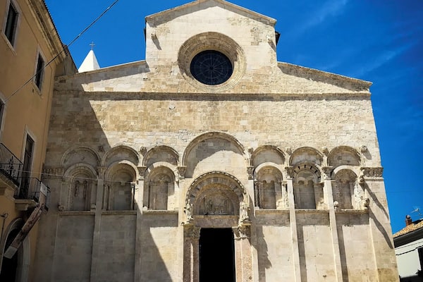 Eine historische Kirche mit einem großen Rundfenster und mehreren Bögen.