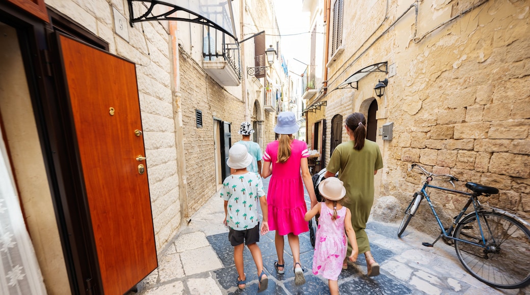Family of tourists waking in streets Bari, Puglia, South Italy.