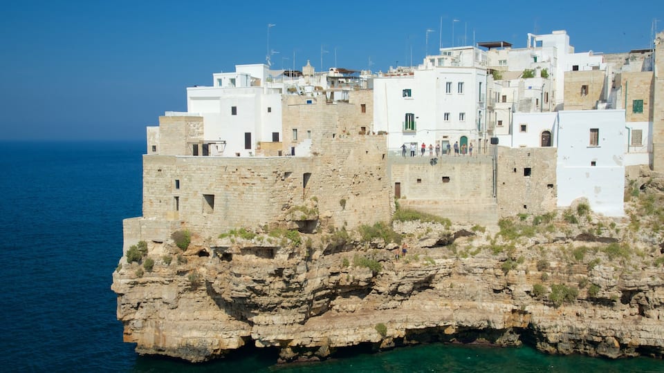 A coastal town with white buildings perched on rocky cliffs overlooking the sea.