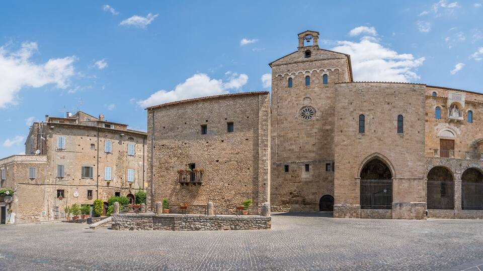 A historic stone building with a round tower and arched windows.
