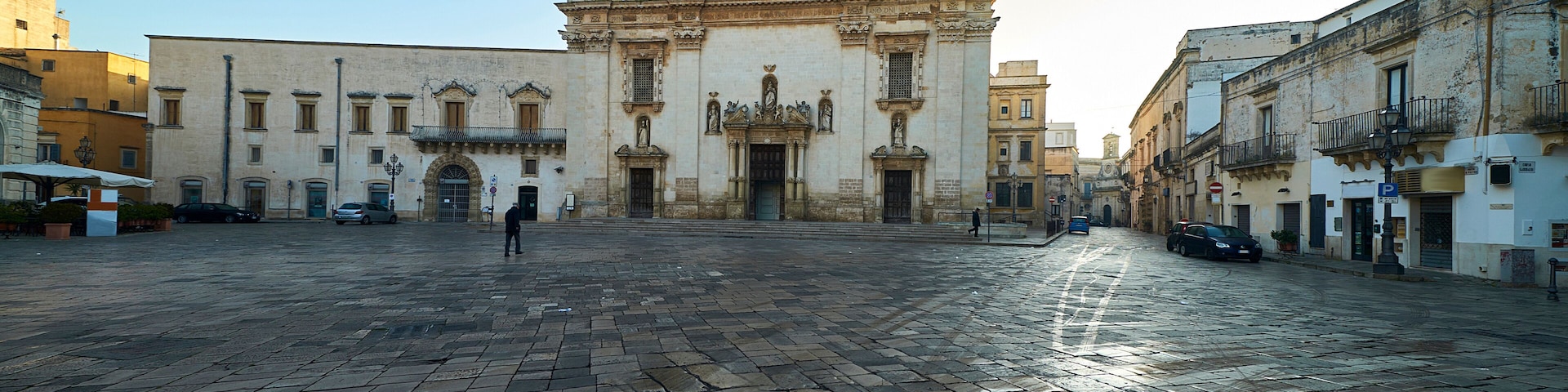 A historic plaza with a prominent church featuring ornate architecture and a cobblestone pavement.