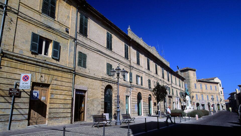 A historic building with arched windows and a cobblestone street.