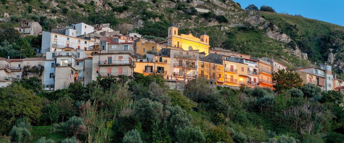 A hillside town with colorful buildings and lush greenery.